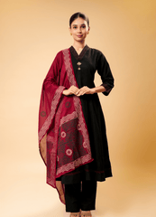 Woman wearing a black outfit with a red patterned dupatta 